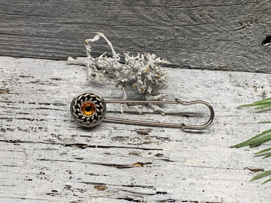 Ponchonadel Brosche aus Metall – Ornament mit bernstein-orange Strass